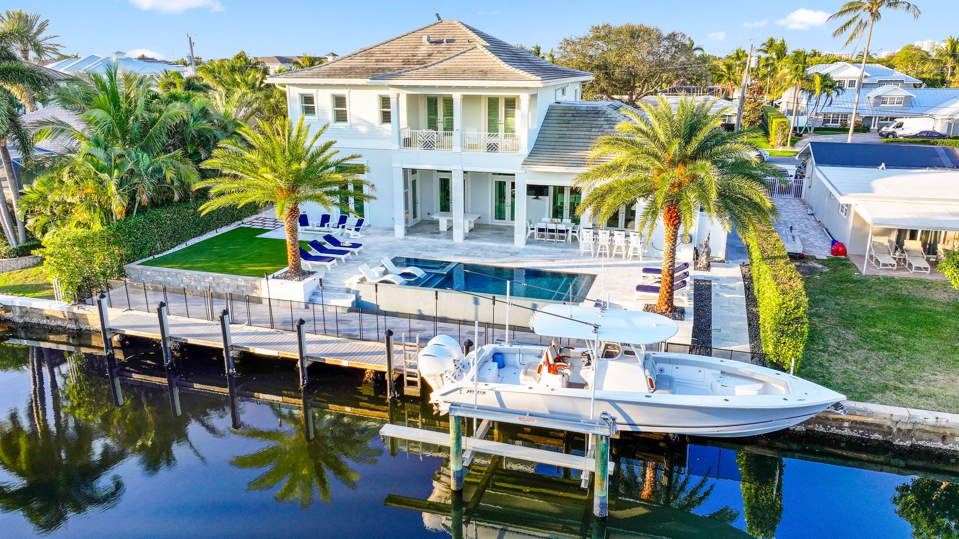Florida residential waterfront with a private boat dock, boat lift and seawall on a calm intracoastal waterway